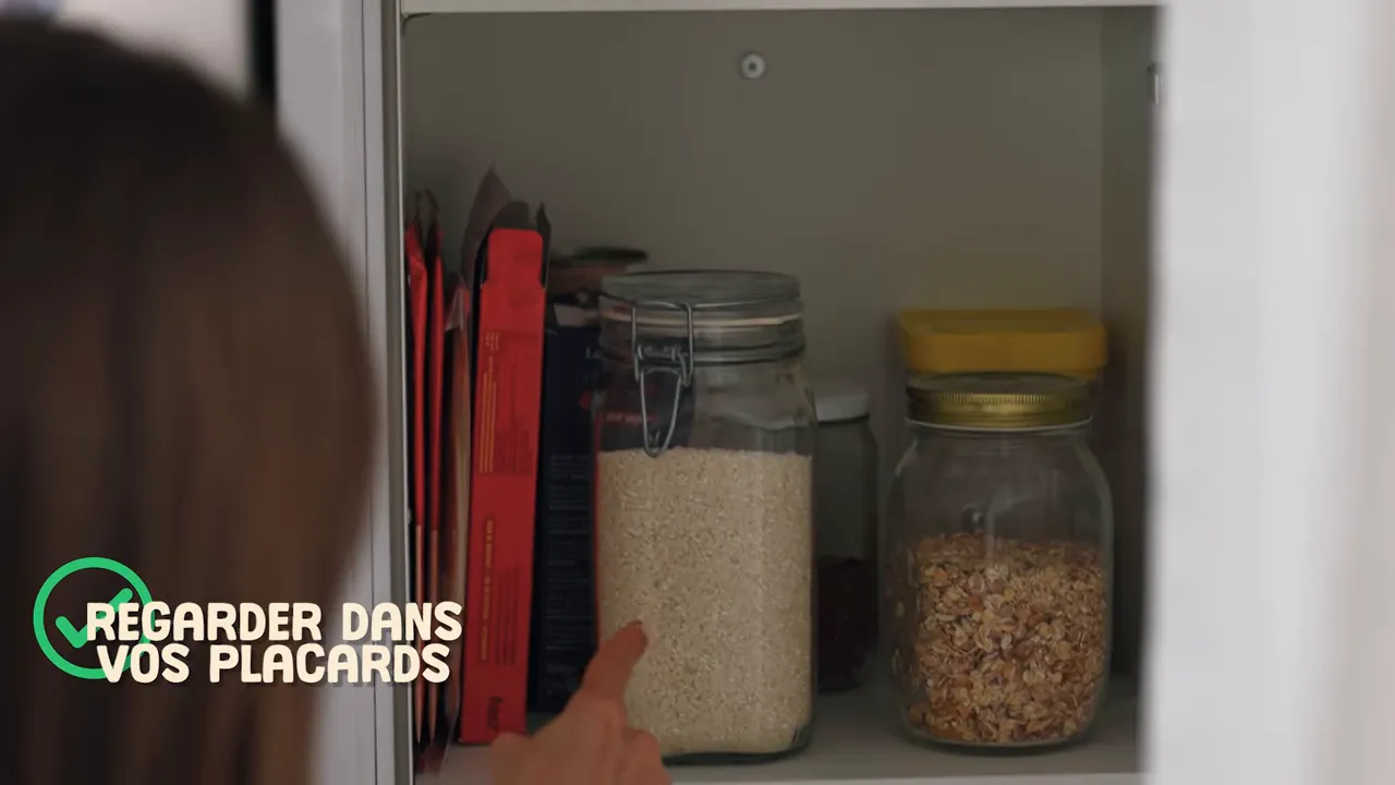 Main pointant un bocal de riz et un bocal de granola dans un placard, texte à l’écran 'REGARDER DANS VOS PLACARDS'.